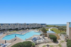 Un hôtel doté d’une piscine, de plusieurs balcons et offrant une vue sur l’océan.