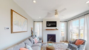 Ein geräumiges Wohnzimmer mit Kamin, einer großen Karte an der Wand und einem Schild für Atlantic Beach Realty.