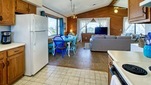 Une cuisine compacte équipée d’un réfrigérateur, d’une cuisinière et d’un coin repas avec des chaises bleues.