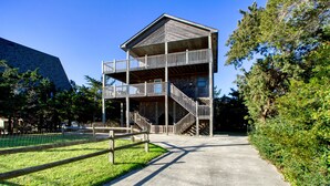 Un immeuble à plusieurs étages doté d’un balcon au deuxième étage et d’un escalier menant au troisième étage.