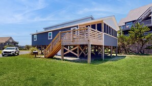 A two-story house with a wooden deck and a staircase leading to the second floor. - Waterfront Home on Bulk-Headed Lot w/ Private Hot Tub, Sound View, Shared Pool (Avon)