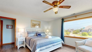 A bedroom with a bed, bedside tables, a ceiling fan, and a window with a view. - Waterfront Home on Bulk-Headed Lot w/ Private Hot Tub, Sound View, Shared Pool (Avon)
