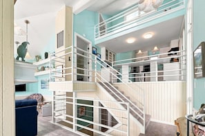 A multi-level interior with a staircase, a dining area, and a living space with a sofa and a coffee table. - Oceanfront Community Pool, New Owners, Newly Renovated, and dog friendly (Avon)