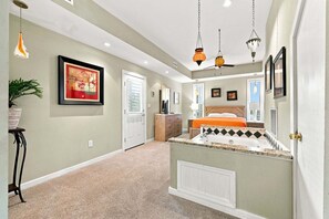 A hallway leading to a bedroom with a bed, a dresser, and a large window. - Oceanfront Community Pool, New Owners, Newly Renovated, and dog friendly (Avon)