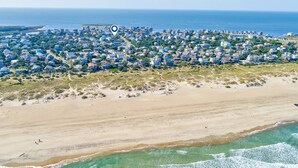 Luchtbeeld van een kustgebied met huizen, een strand en de oceaan.