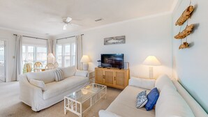 A modern living room with white furniture, a flat-screen TV, and decorative wall art. - FKA Kimogener Point - ocean views, WiFi, W/D, balcony, pool & beach access (Avon)