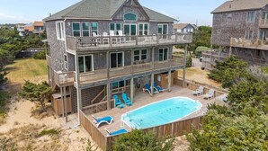 A two-story house with a balcony, a swimming pool, and outdoor furniture. - Oceanfront house with private pool, hot tub, & washer/dryer (Avon)