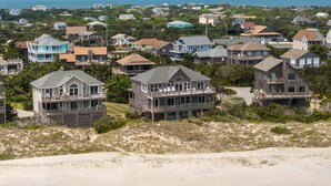 A coastal residential area with houses featuring balconies and ocean views. - Oceanfront house with private pool, hot tub, & washer/dryer (Avon)