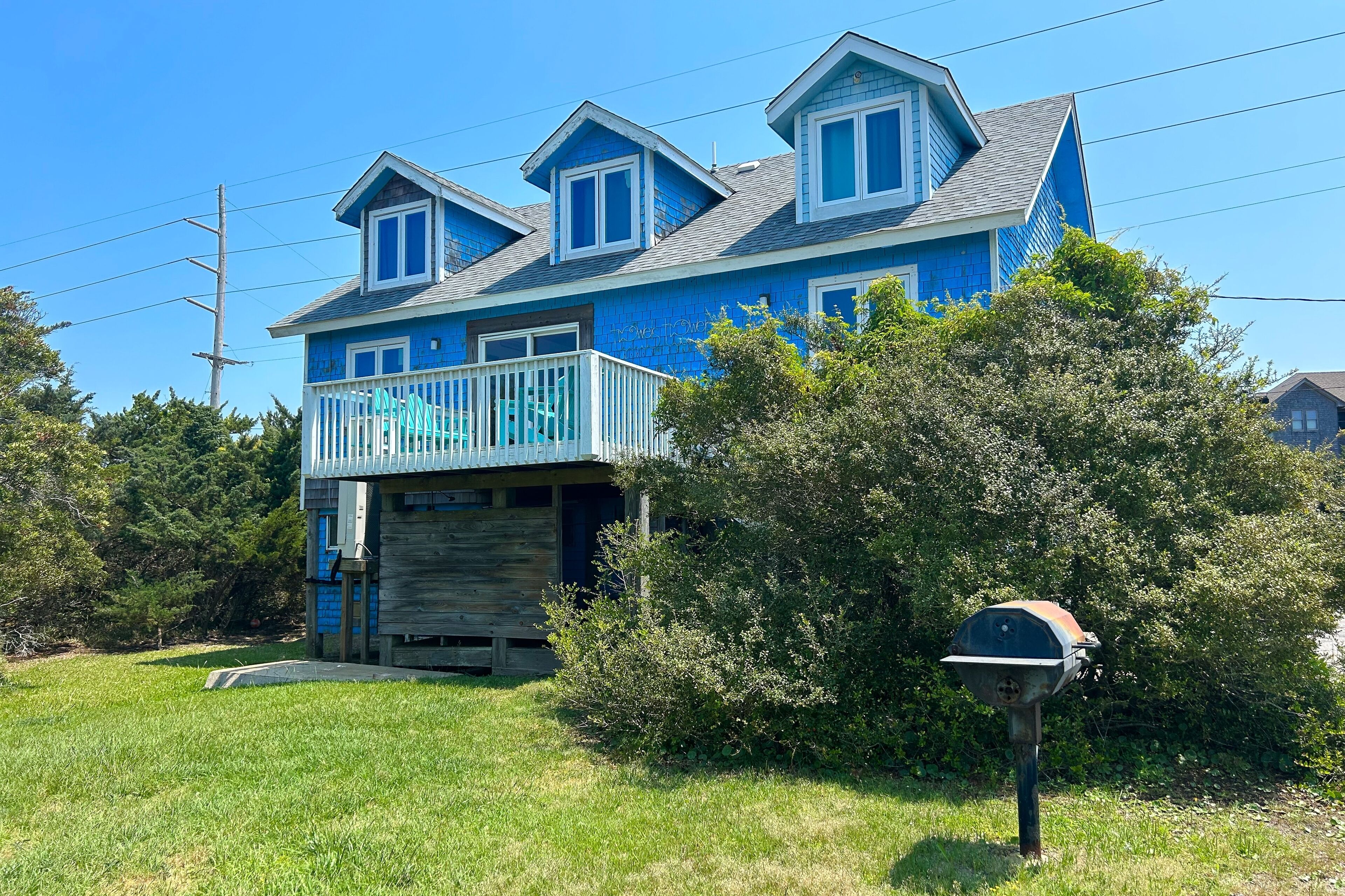A two-story house with a blue exterior and a wooden garage door.