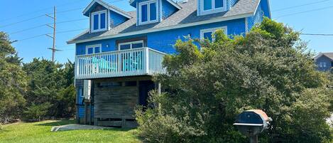 A two-story house with a blue exterior and a wooden garage door.