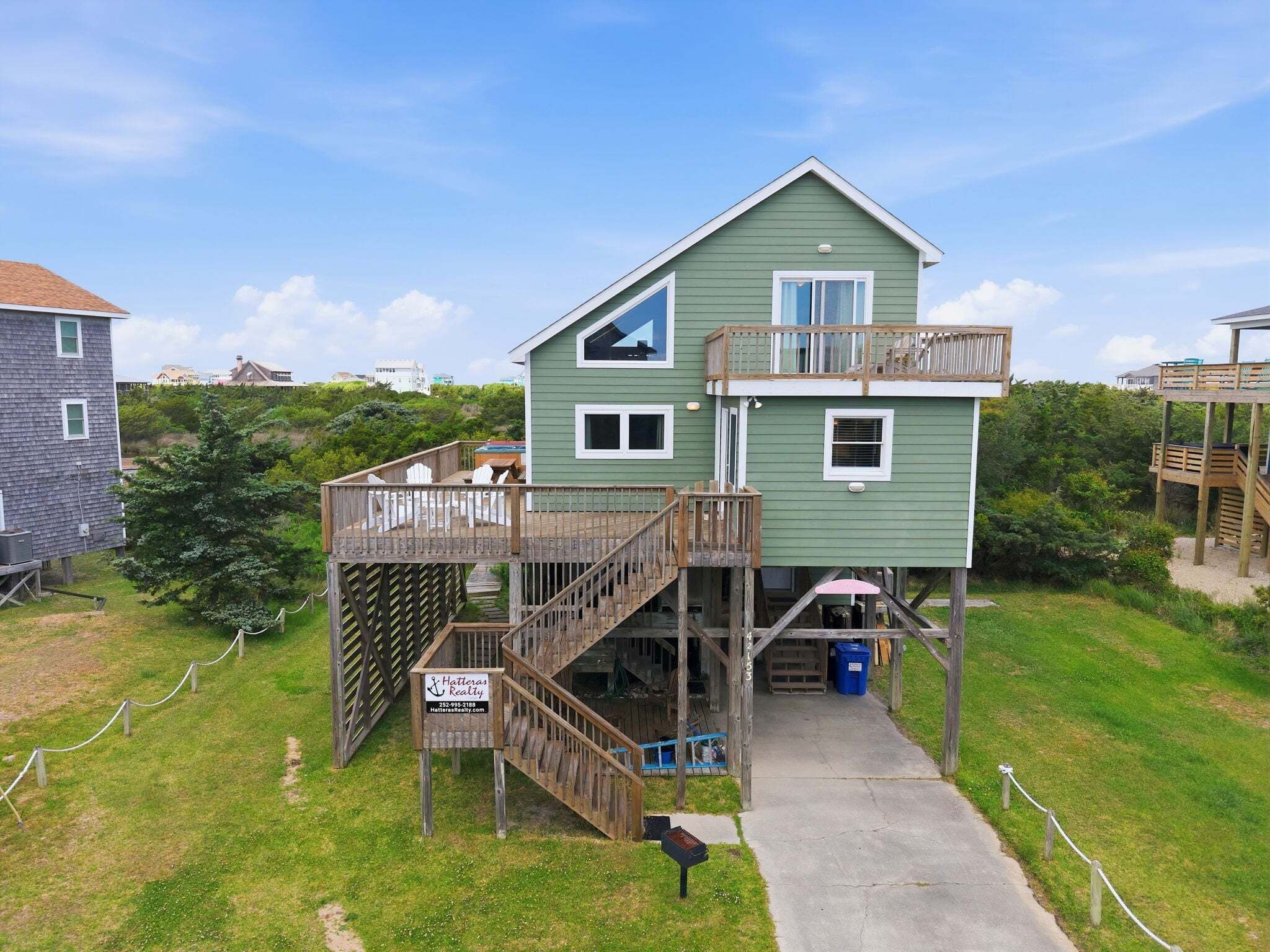 A two-story house with a deck and a staircase leading to the upper floor.