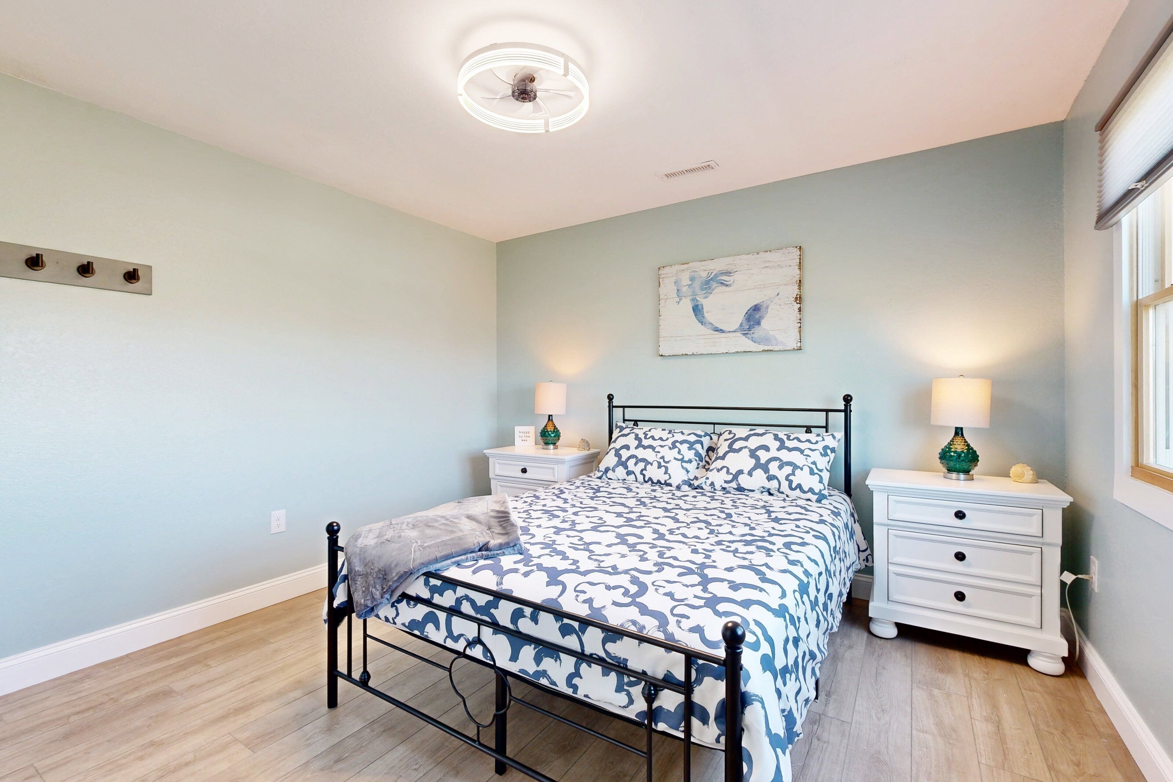 A bedroom with a bed, nightstands, and a ceiling fan.