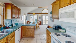 Una cocina con armarios de madera, una isla central, un microondas y una estufa.