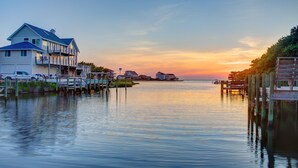 A waterfront property with a large house, dock, and pier. - Huge, canal-front home w/private hot tub, WiFi, central AC, washer & dryer, dock (Frisco)