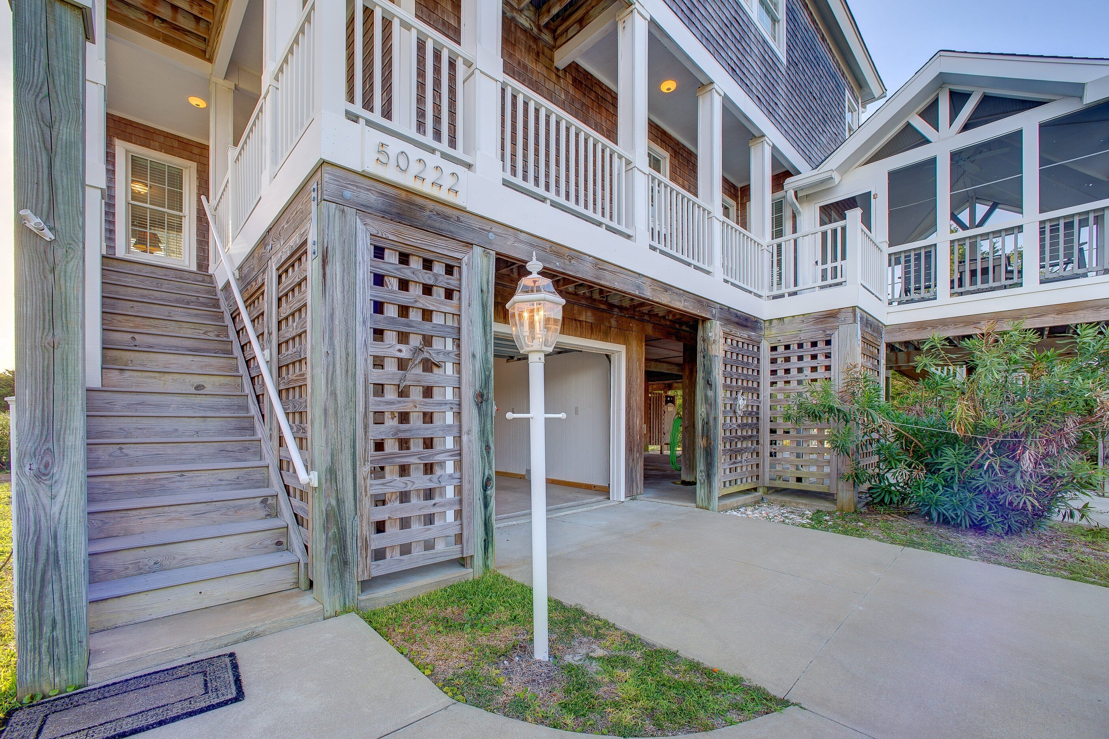 A two-story house with a wooden exterior, a balcony, and a garage.