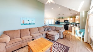 A living room with a sectional sofa, a wooden coffee table, and a ceiling fan. - Spacious dog-friendly haven with private pool, hot tub, pool table, & AC (Avon)