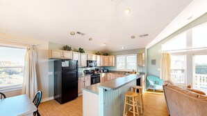 A modern kitchen with a central island, a dining area with a table and chairs, and a living room with a sofa and a window. - Spacious dog-friendly haven with private pool, hot tub, pool table, & AC (Avon)