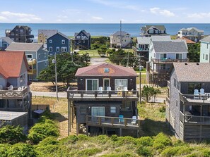 A coastal residential area with houses featuring balconies and decks, some with views of the sea.