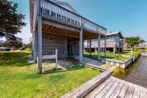Une propriété située au bord de l’eau, dotée d’un porche couvert, d’une terrasse en bois et d’un petit quai.