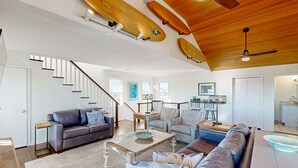 A spacious living room with a high ceiling, wooden beams, and a staircase. - Sunset Park: Short Walk to the Beach, Great Views (Avon)