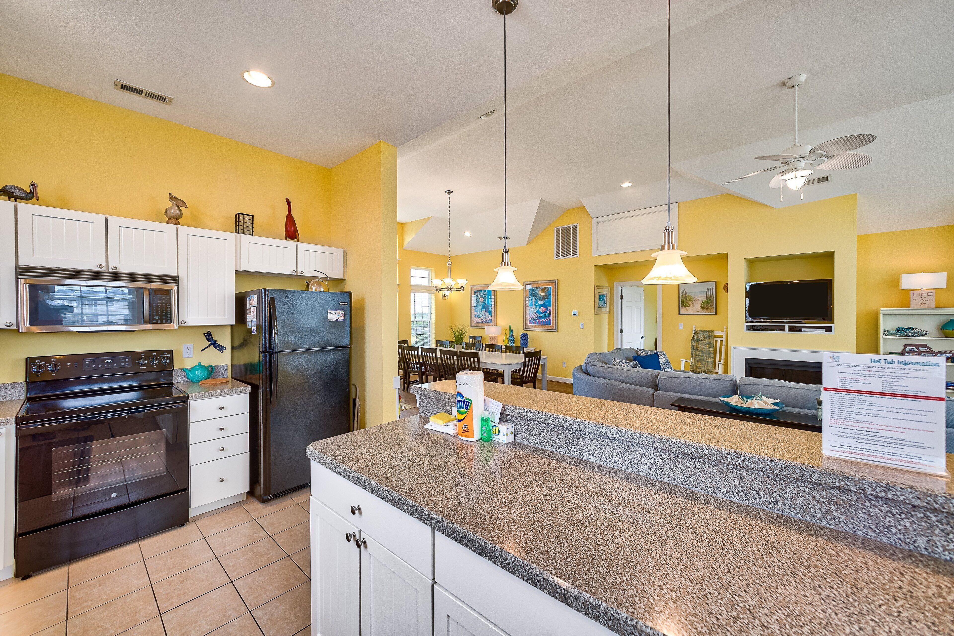 A kitchen with white cabinets, a stainless steel refrigerator, and a granite countertop.