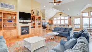 A spacious living room with a fireplace, a television, and a large sofa.