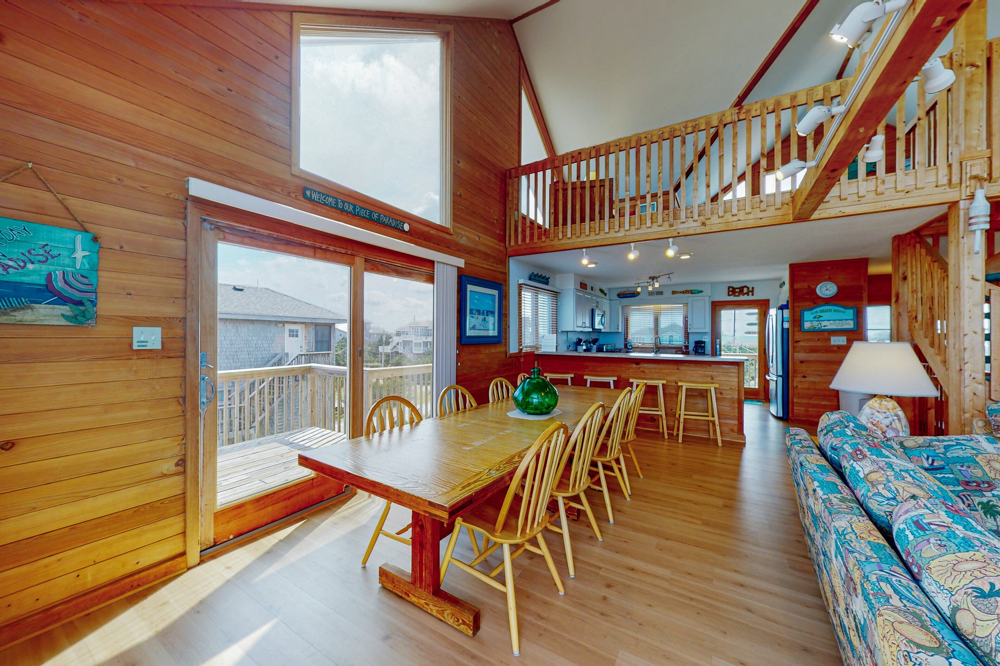 A wooden interior with a dining area, a sofa, and a staircase.