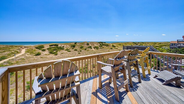 A wooden deck with Adirondack chairs overlooking a beach. - Yankee Clipper 204: Oceanfront, balcony, ocean views (Avon)