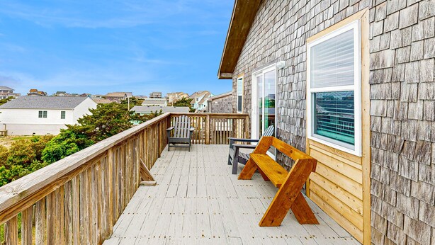 A wooden deck with a bench and a table, overlooking a residential area. - Tarpon Drive Hideaway: dog-friendly duplex with balcony (Avon)
