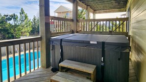 Une terrasse en bois avec un jacuzzi et une piscine.