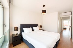 Camera da letto moderna con un letto grande, lampade sui comodini, una testiera scura e un lampadario.