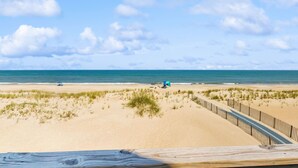 A beach with a wooden boardwalk, sandy dunes, and a clear blue sky. - Fun beachfront home w/shared pool, WiFi, private washer & dryer, central AC (Avon)