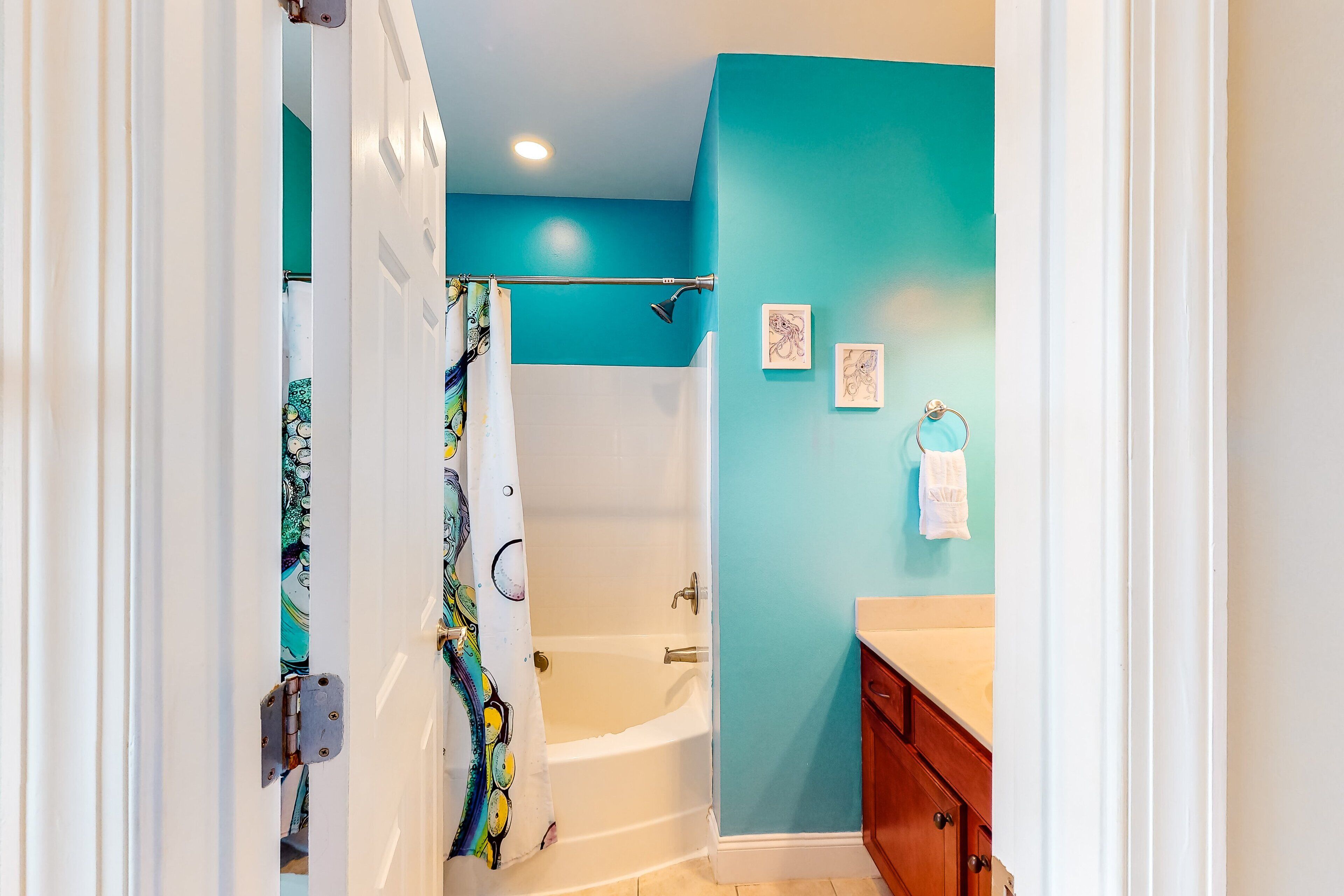 A bathroom with a bathtub, a shower, and a vanity with a sink.