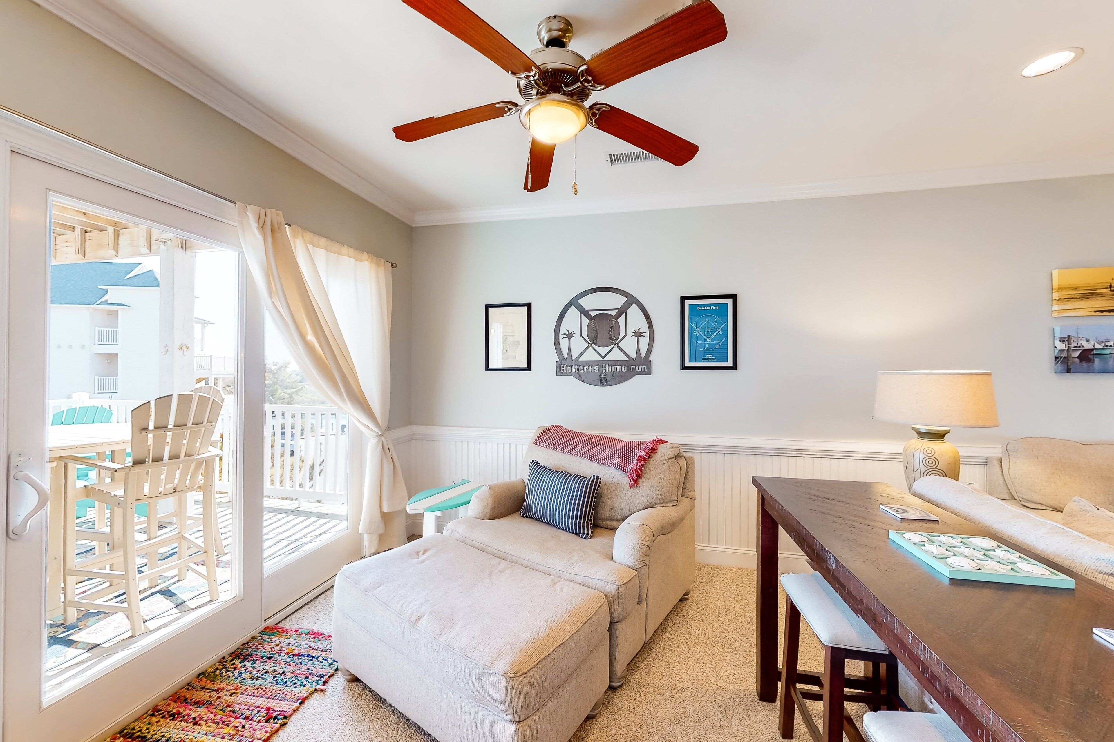 A living room with a ceiling fan, a sofa, a coffee table, and a dining table.