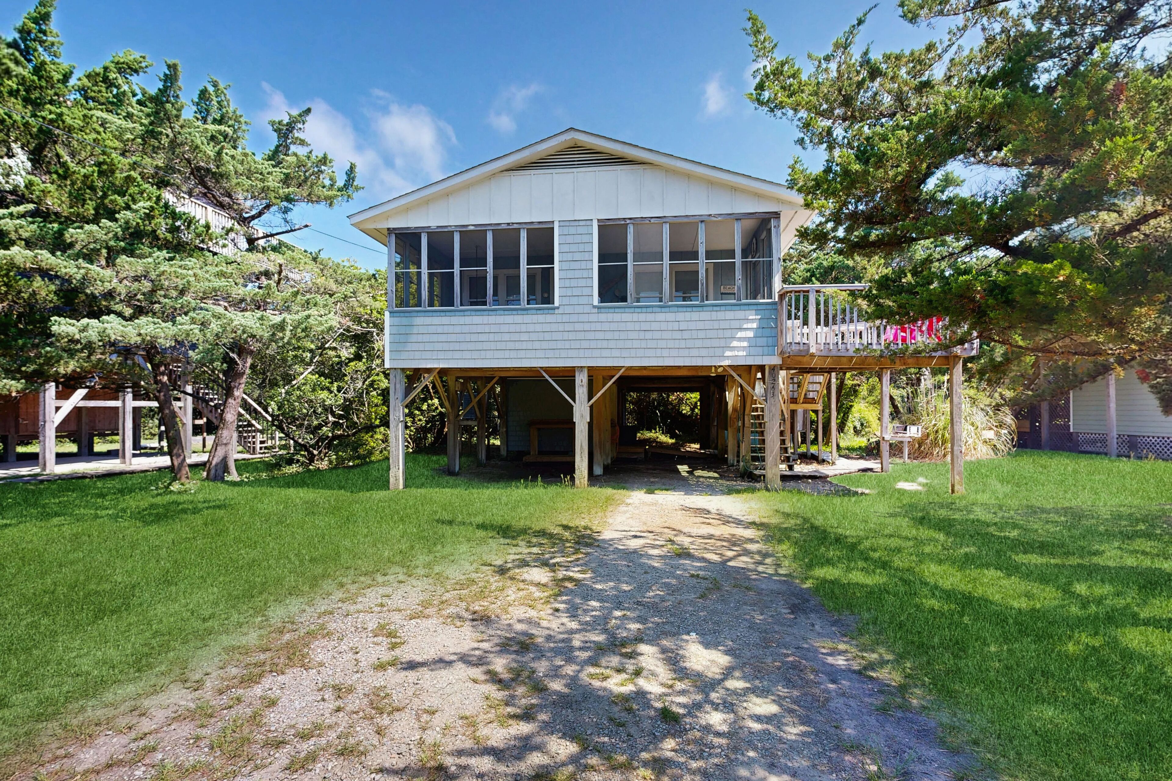 A two-story house with a covered porch and a small deck.
