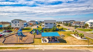 A playground with slides and a picnic area, surrounded by houses and a road. - Ocean-view townhome with pool access, playground, outdoor shower - dog-friendly (Surf City)