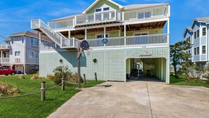 Ein zweistöckiges Gebäude mit Balkon und Treppe, mit einem Schild, das angibt, dass es zum Carolina Beach Resort gehört.
