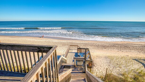 A wooden boardwalk leading to a beach with a clear view of the ocean. - Oceanfront home with ocean views, beach access, tanning deck & private elevator (Surf City)