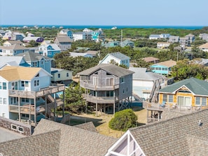 A coastal residential area with houses featuring balconies and a prominent wooden structure with a deck.