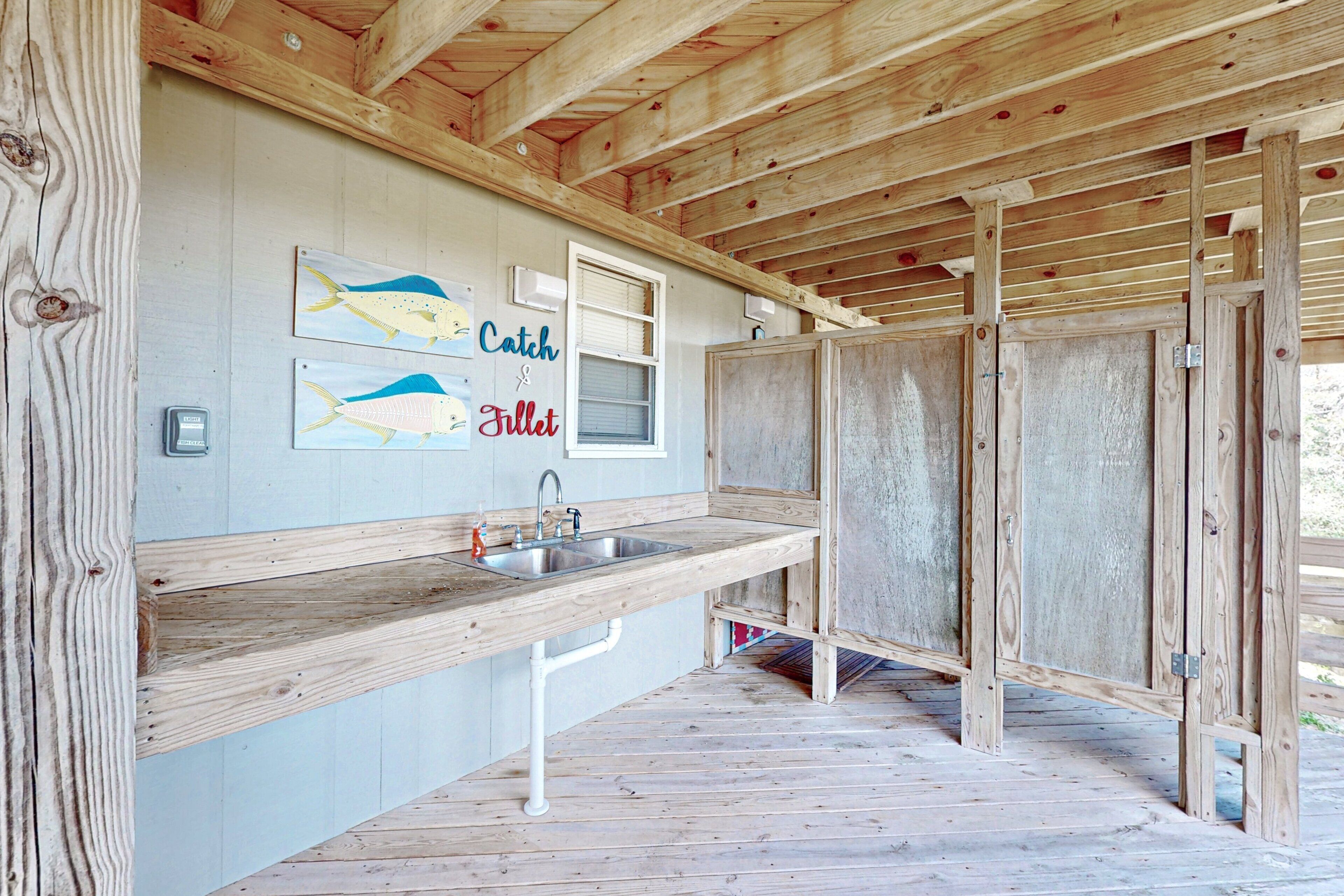Une cabane en bois avec un coin cuisine, un évier et une fenêtre.