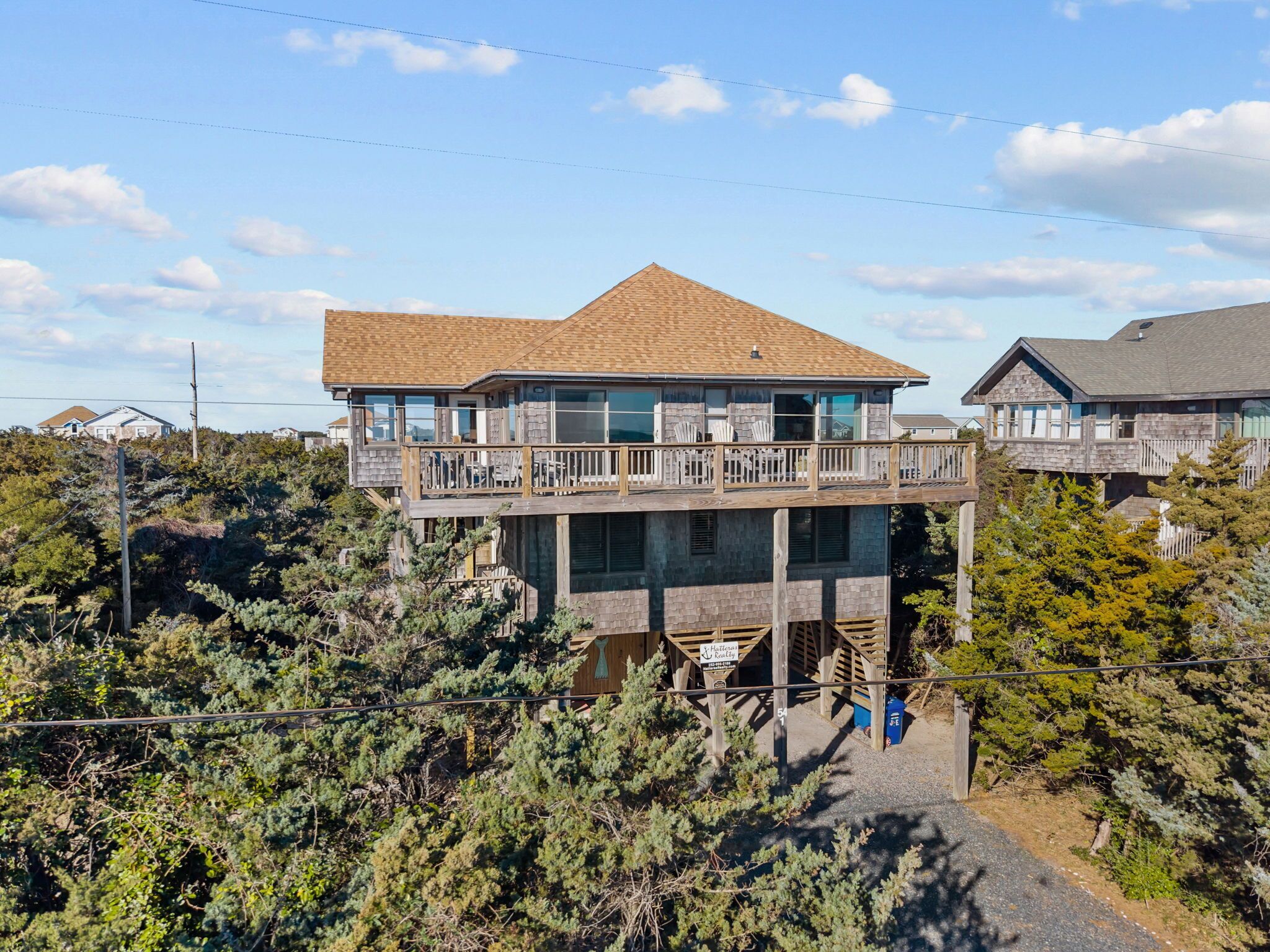 A two-story house with a balcony and a sign indicating it's a rental property.