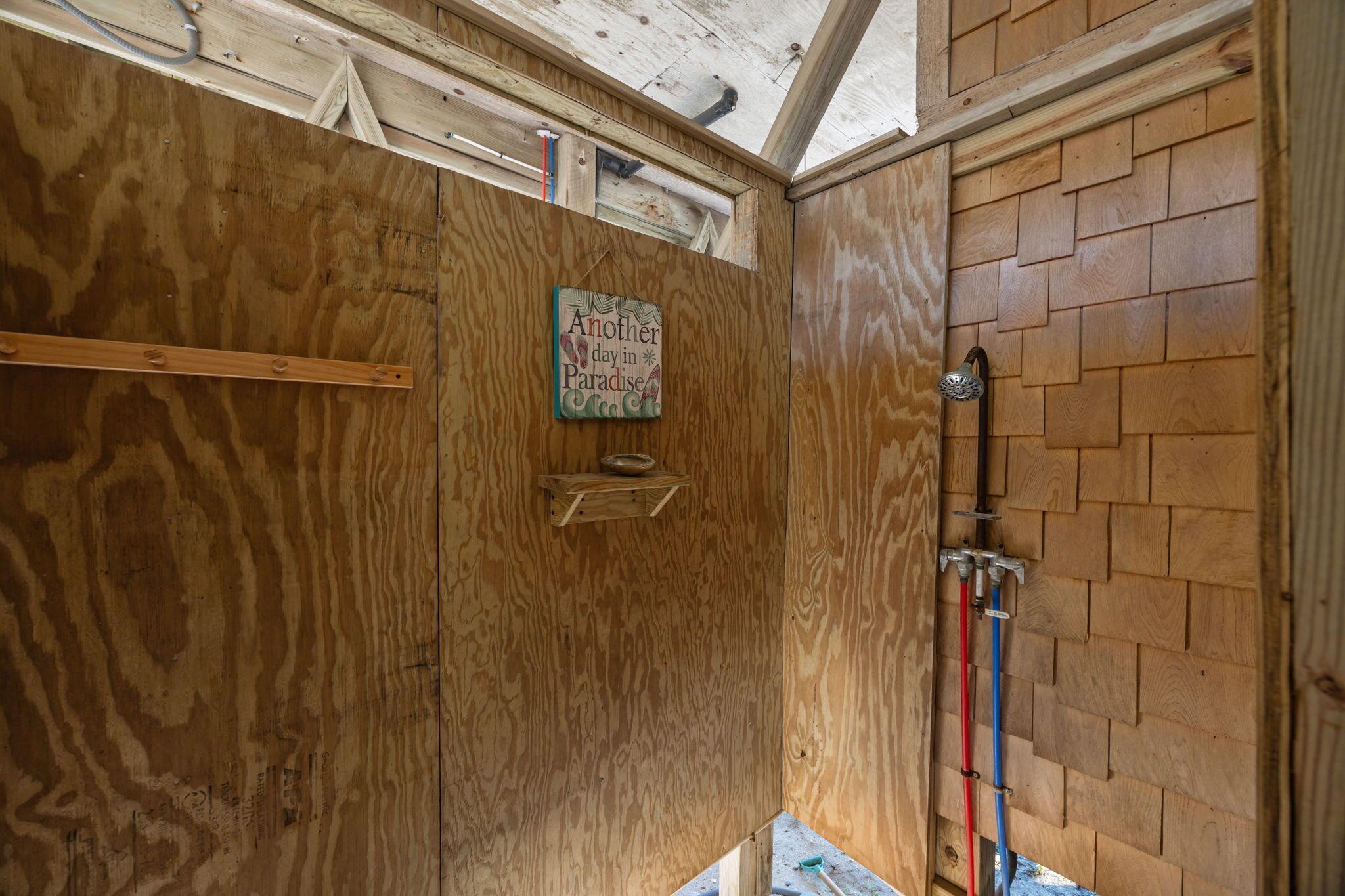 A wooden interior with a sign that reads "Another day in Paradise."