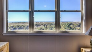 A room with a large window offering a view of a hilly landscape. - Ocean and waterway-view duplex - pool, beach access, washer/dryer, central AC (Topsail Beach)