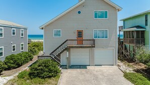 A two-story house with a front garage, a small balcony, and a view of the beach. - Oceanfront home with beach access, a game room, washer/dryer, & central AC (Topsail Beach)