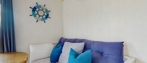 Una habitación con cama, una mesa y aire acondicionado instalado en la pared.