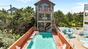 A two-story building with a balcony, a swimming pool, and outdoor seating. - Casablanca: Avon beach escape with themed suites, pool, hot tub & ocean views. (Avon)