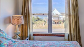 Una camera da letto con un letto, una lampada e una finestra con tende.