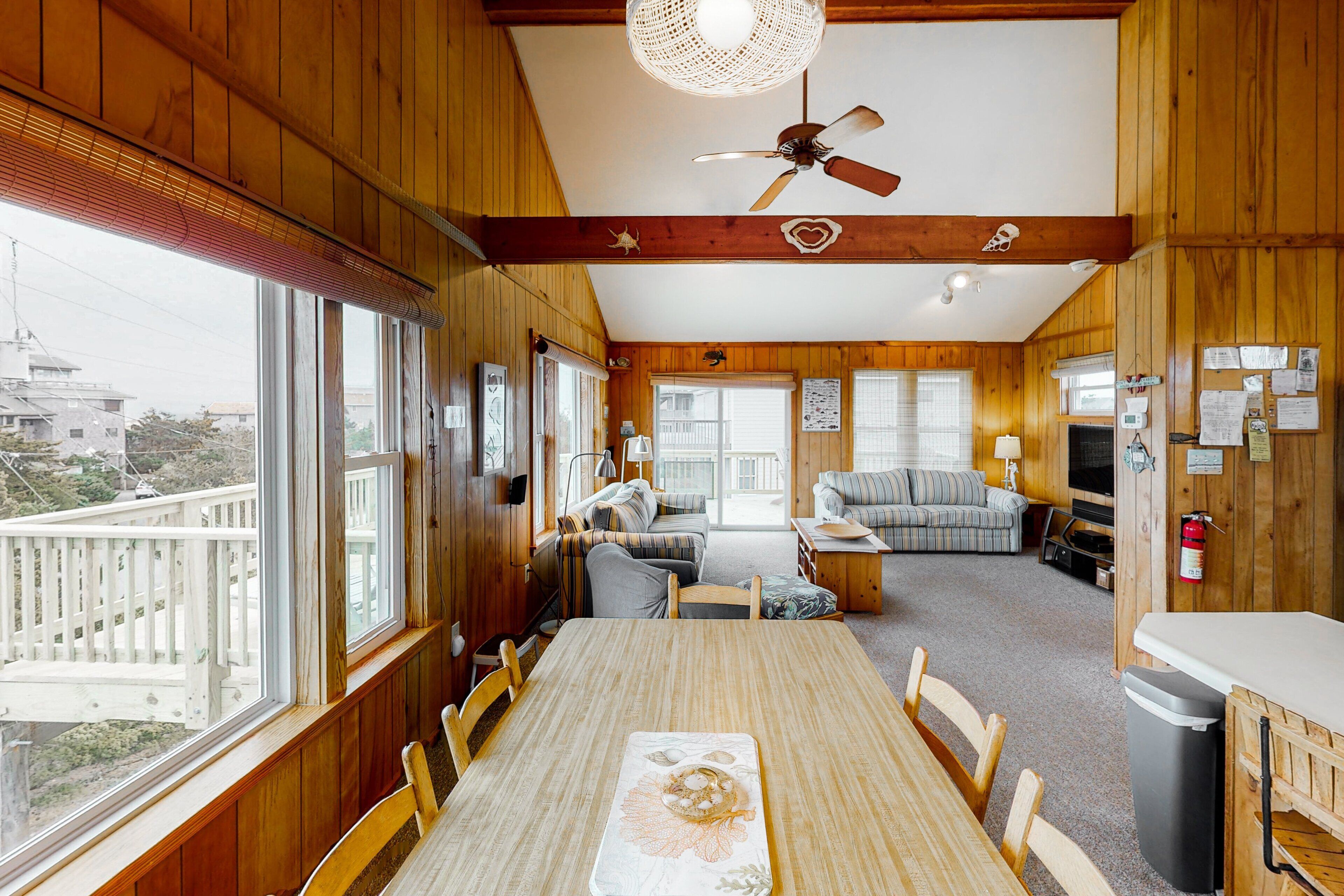 Une cabane en bois comprenant un coin repas, un salon et un balcon avec vue.