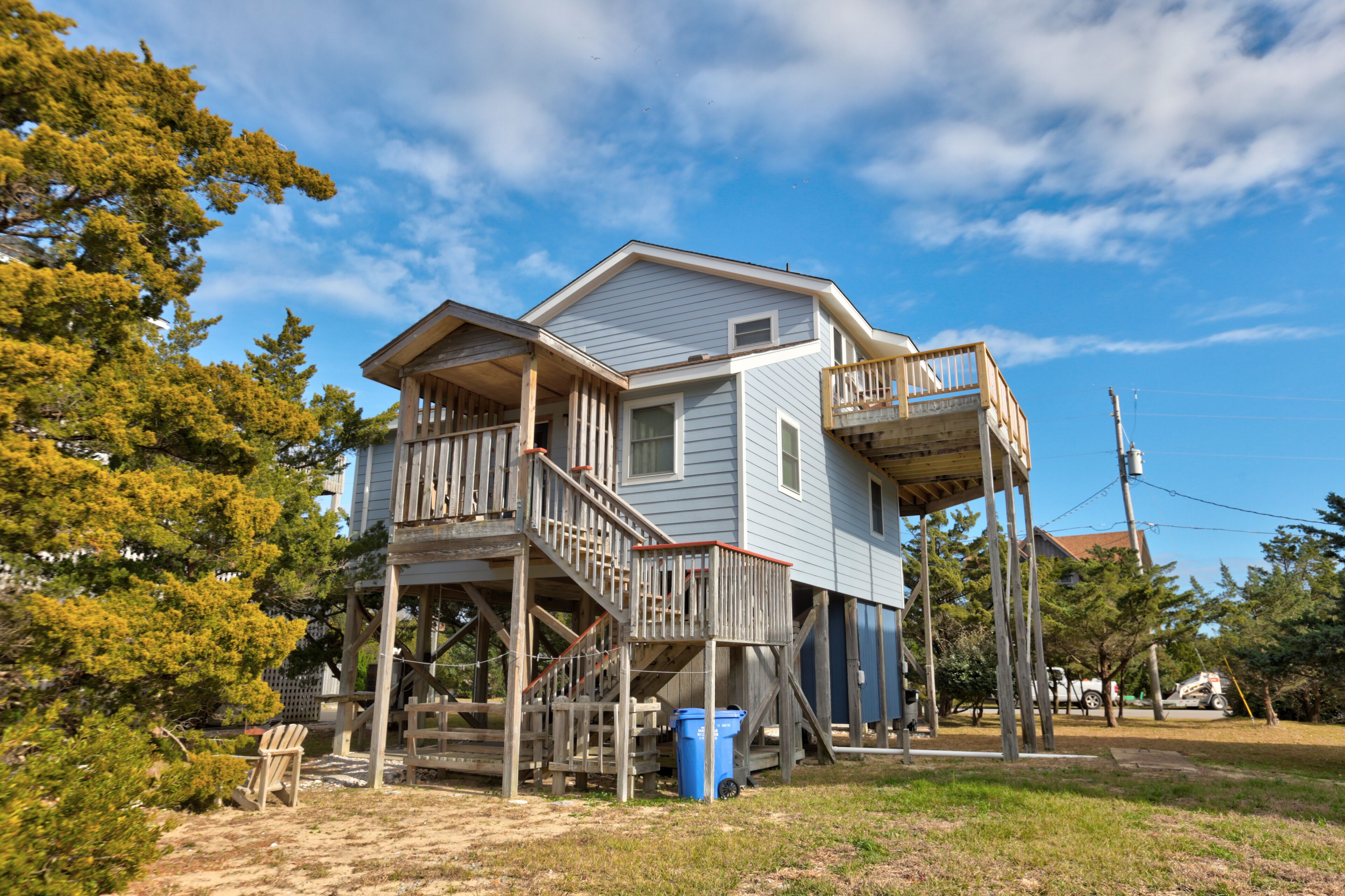 A two-story house with a wooden deck and a balcony.