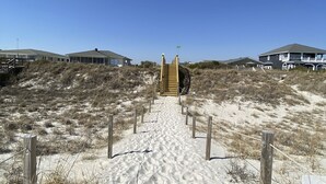 A sandy pathway leading to a wooden staircase with a sign indicating a beach access point. - Coastal home with large deck, close to beach and local attractions (Topsail Beach)